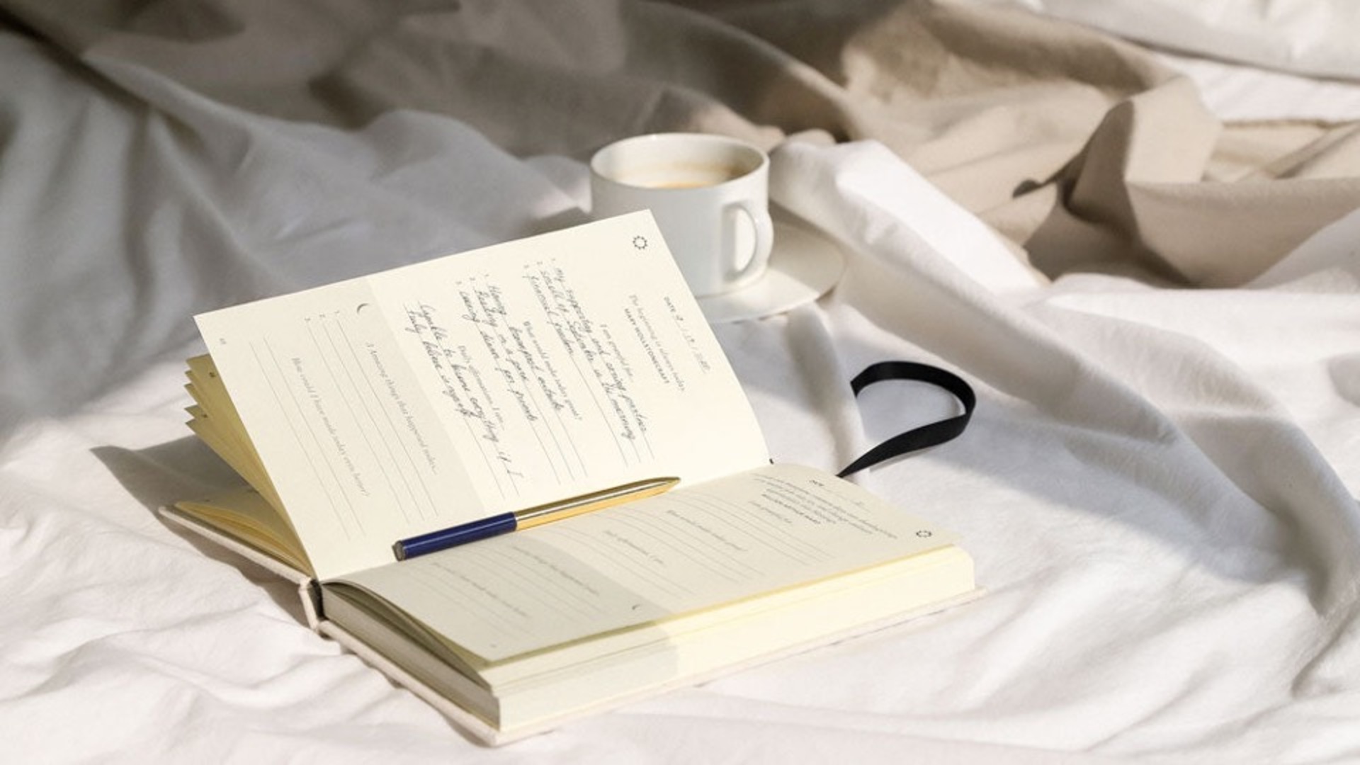 Un journal et une tasse de café situés dans un lit.