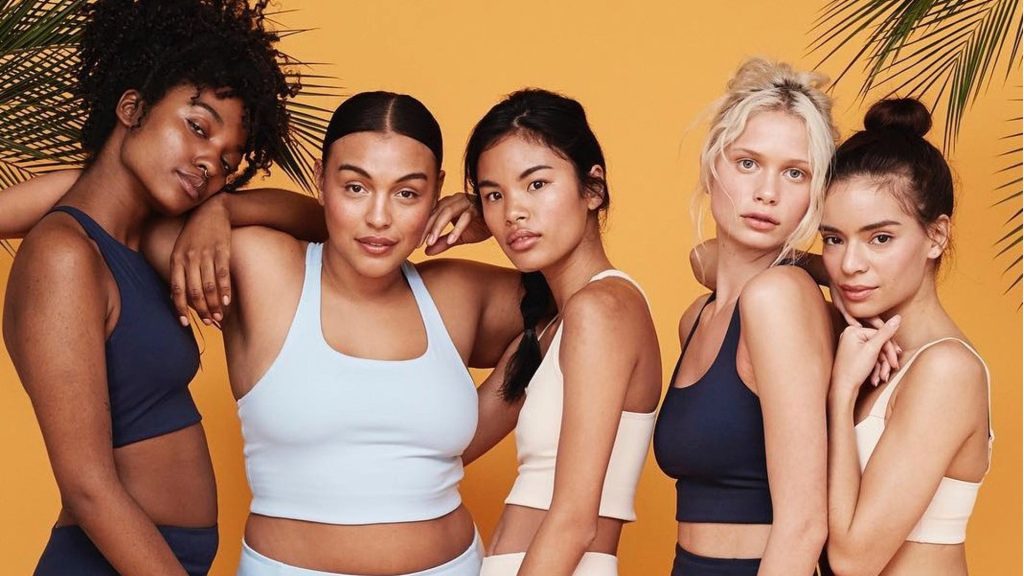 Cinq femmes de morphologies et ethnies différentes posent en vêtements de sport pour la compagnir Girlfriend Collective