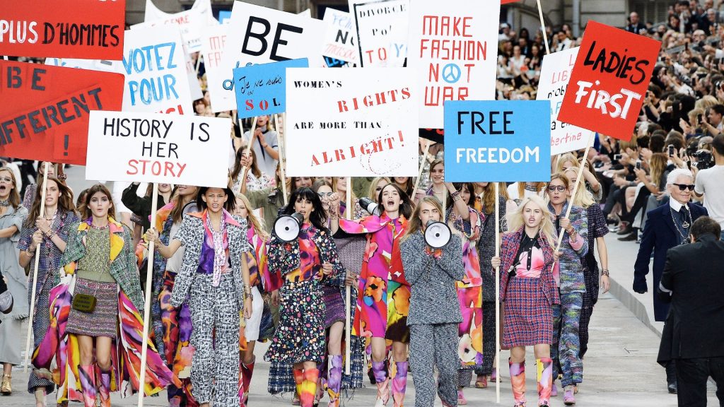 Des mannequins de sexe féminin défilent avec des pancartes défendants les droits des femmes lors d'un défilé de mode organisé par Chanel au Grand Palais en automne 2014.