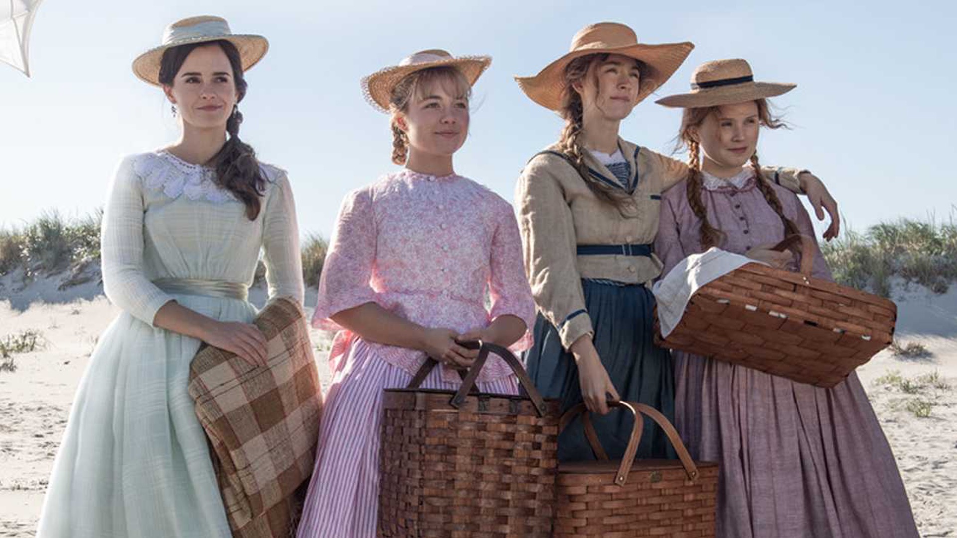 Photographie provenant du film «Les quatre filles du Docteur March» des personnages principals, soit quatre femmes, à la plage tenant des paniers à picnic.