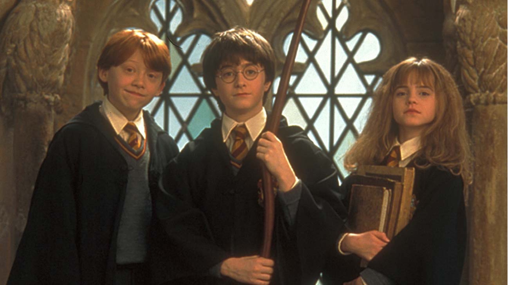 Harry Potter, Hermione Granger et Ron Weasley sont devout dans les marches de Poudlard.